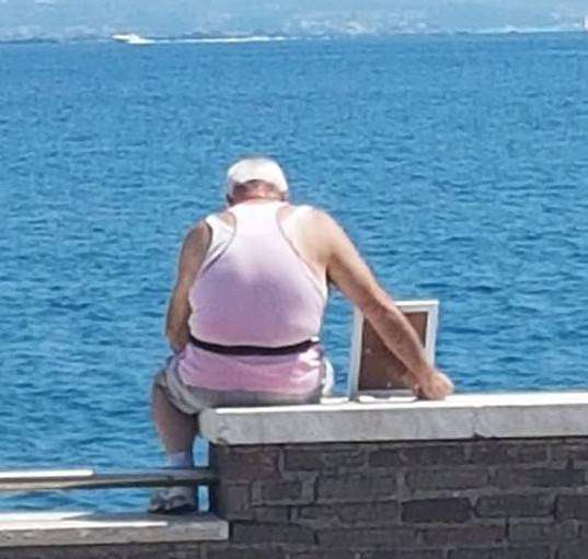Porta la foto della moglie con se al mare. L'immagine virale che commuove il WEB